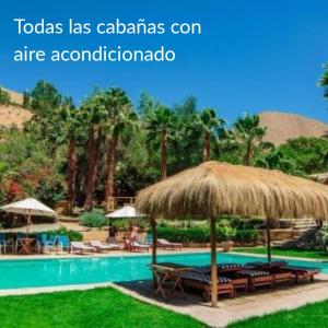 un complexe avec une piscine et un parasol dans l'établissement Refugio Misterios del Elqui, à Pisco Elqui