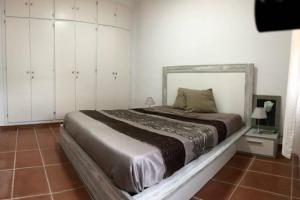 um quarto com uma cama grande e armários brancos em ALOJAMIENTO CON JARDIN 20KM BARCELONA em Vilassar de Dalt