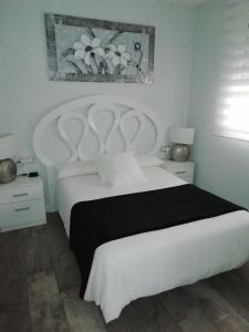 トレモリノスにあるCarihuela New Design On Beachのベッドルーム1室(白黒のヘッドボード付きの白いベッド1台付)