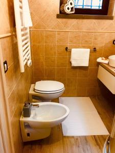 a bathroom with a toilet and a sink at Alice’s House in Fonteno +42 photos