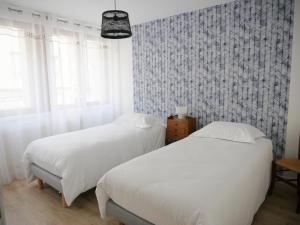 2 łóżka w sypialni z malowidłem ściennym w obiekcie Superbe appartement en centre ville avec terrasse w mieście Thonon-les-Bains