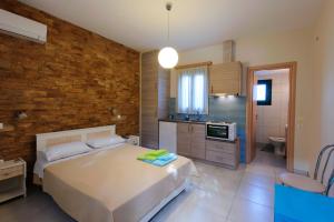 a bedroom with a large bed and a bathroom at Holiday Rooms in Otziás