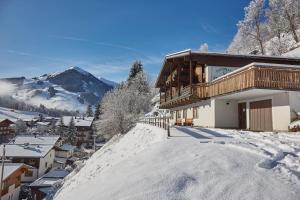 eine Skihütte im Schnee in einer Stadt in der Unterkunft Chalet Lodge Hubertus in Saalbach-Hinterglemm