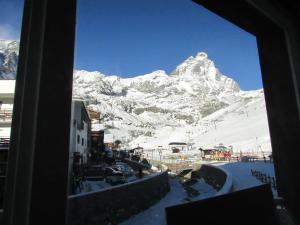 una ventana con vistas a una montaña nevada en Maison Meynet Mountain Charm en Breuil-Cervinia