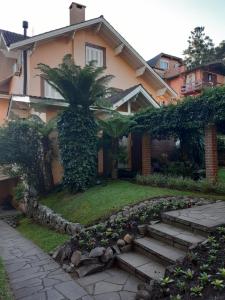 una casa con una palmera y escaleras delante en Dona Beatriz 11, en Gramado