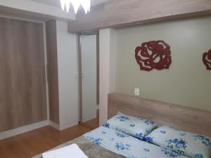 um quarto com uma cama com almofadas azuis e uma placa na parede em Dona Beatriz 11 em Gramado