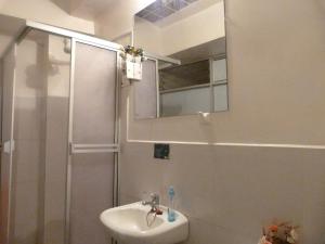 Un baño con ducha, lavabo y espejo. en Piacere Hotel, en La Paz