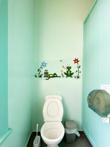 a bathroom with a toilet in a blue wall at Noah's Ark Backpackers in Greymouth