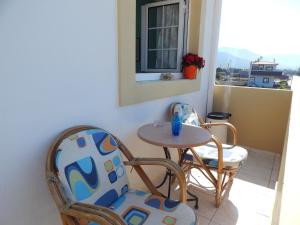 - Balcón con mesa pequeña y 2 sillas en Malia Star Apartments, en Malia