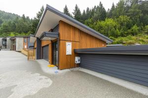 a group of buildings with trees in the background at MyHolidays - The Four Seasons Queenstown in Queenstown