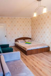 1 dormitorio pequeño con 1 cama y 1 sofá en Квартира по улице Федорова 1, en Kiev