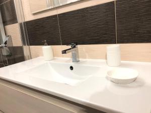 een witte wastafel in een badkamer met een spiegel bij Elle's House in Savona