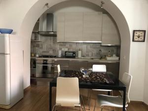 een keuken met een zwarte tafel en witte stoelen bij Elle's House in Savona