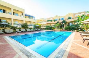 a swimming pool in front of a hotel at Helios Apartments in Kato Daratso