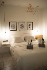 a bedroom with a large white bed with two chairs at ChrisAndro Apartments in Athens
