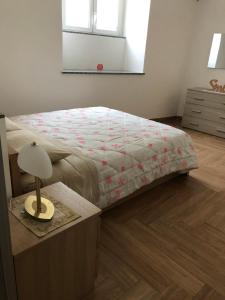 een slaapkamer met een bed en een tafel met een lamp bij Elle's House in Savona