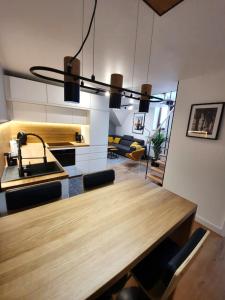 a kitchen and dining room with a wooden table at Rister Apartments Dwernickiego in Krakow