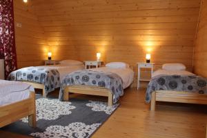 a room with four beds in a wooden room at Chata Albertówka in Groń