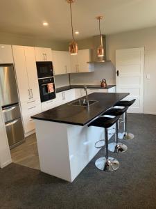 a kitchen with a black counter top and a sink at Quiet home with modern touch in Dunedin