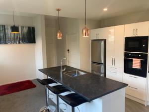 uma cozinha com um lavatório e uma bancada em Quiet home with modern touch em Dunedin