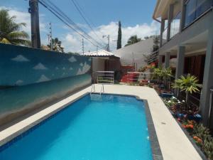 a swimming pool in front of a house at Flor de Limão Hotel Boutique in Coroa Vermelha