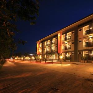 an empty street in front of a building at night at The Siri Place in Udon Thani
