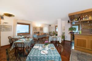 a dining room with tables and chairs and a kitchen at Hotel Terme in Bormio