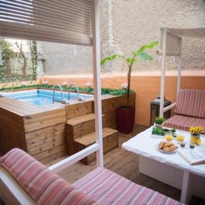uma banheira de hidromassagem num pátio com uma mesa em ChrisAndro Apartments em Atenas