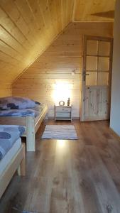 a room with two beds in a wooden cabin at Agroturystyka "Domek pod Praszywką" in Rycerka Górna