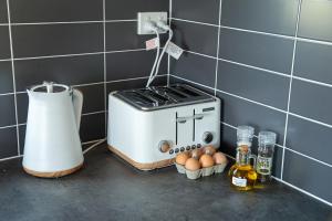 um balcão com uma torradeira e ovos numa cozinha em OMARU FARM STAY em Ventnor