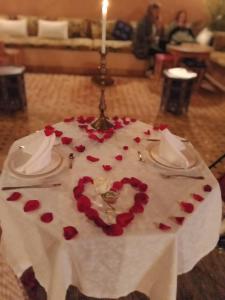 馬拉喀什的住宿－KOUTOBIA ROYAL，一张桌子,上面有一块蛋糕,上面有蜡烛和红玫瑰