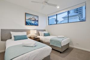 a bedroom with two beds and a window at Allure Mooloolaba in Mooloolaba