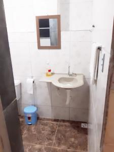 a bathroom with a sink and a mirror and a toilet at Pousada Mara Mar Niterói in Niterói