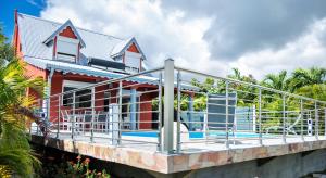 a house with a balcony with a railing at VILLA D'ALICE 1 in Sainte-Anne
