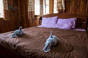 two stuffed animals are laying on a bed at Pae Maldive Erawan in Chongsadao
