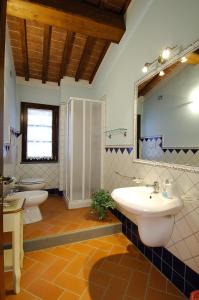 ein Bad mit 2 Waschbecken, einer Dusche und einem Spiegel in der Unterkunft La Corte D'Elsa in Castelfiorentino