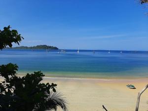 - une vue sur la plage avec un bateau dans l'eau dans l'établissement Starlight Beach Resort, à Ko Phayam