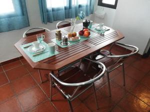 a wooden table with two chairs and fruit on it at Apartamento con vistas al Guadiana in Vila Real de Santo António