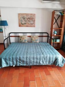 a bed with a blue comforter in a room at Apartamento con vistas al Guadiana in Vila Real de Santo António