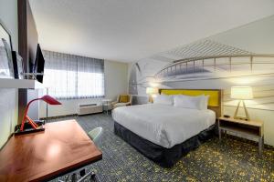 セントルイスにあるSaint Louis Airport Hotelのベッドと机があるホテルの部屋