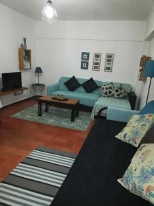 a living room with a blue couch and a table at Apartamento con vistas al Guadiana in Vila Real de Santo António