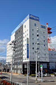 a large white building with a crane on top of it at Dormy Inn Hirosaki in Hirosaki