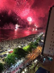 een menigte mensen die vuurwerk kijken op het strand bij Apartamento Frente Mar in Balneário Camboriú