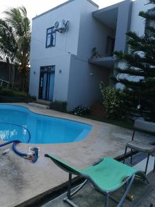 a lawn chair next to a swimming pool at JKB Villa in Pamplemousses Village