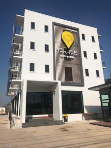 a white building with a yellow onion sign on it at T-NEE Hotel@Udon in Udon Thani