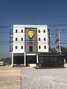 um edifício branco com um coração amarelo pintado nele em T-NEE Hotel@Udon em Udon Thani