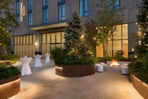 a courtyard with tables and trees in front of a building at Hotel Indigo - Williamsburg - Brooklyn, an IHG Hotel in Brooklyn