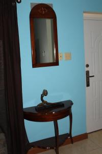 a small table with a mirror on a blue wall at The Artist Place Kensington 1BR New Kingston in Kingston