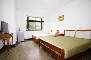 A bed or beds in a room at Fumei Bluebird Homestay