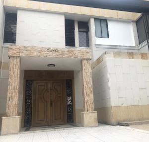 a building with a wooden door in front of it at HOTEL BELEN-La Flora- Cali Valle del Cauca in Cali